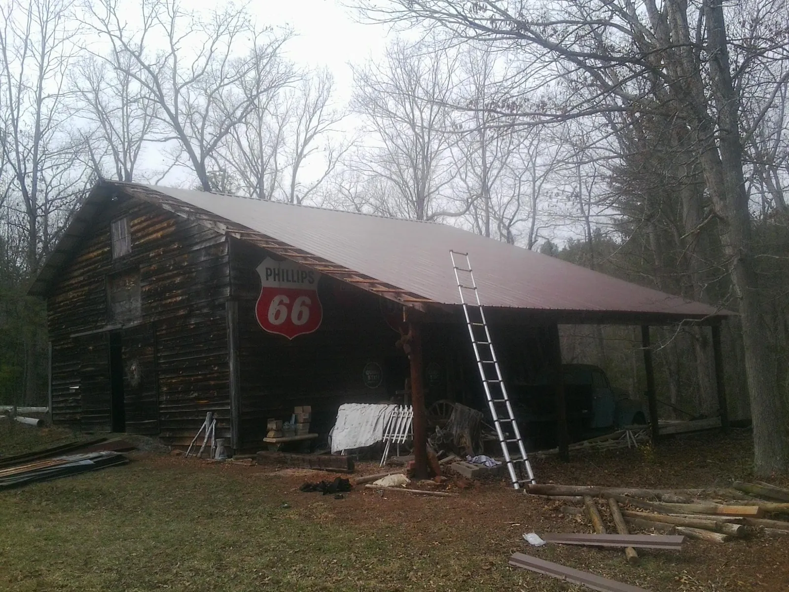 New metal roof on an open sided timber barn with a vintage sign in Beaman