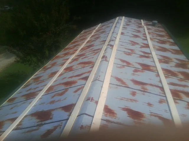 Rusted metal roof panels with new wood purlins before replacement — Storm Damage Roof Repair in Beaman by Roofing Brothers