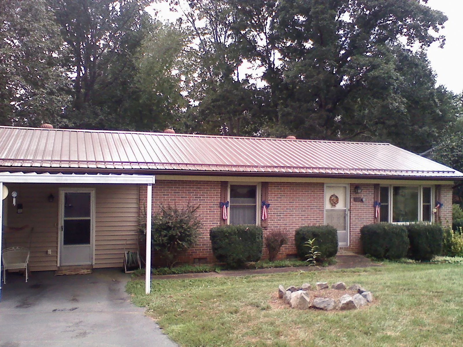 Bronze metal roof and carport on a brick ranch home — Roof Repair work by our crew in Beaman